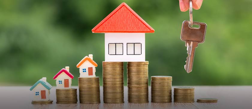 Toy houses on stacks of coins symbolising property investment growth